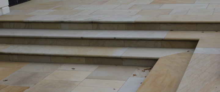 Contemporary sawn stone steps in a soft buff tone, installed in a modern outdoor setting.